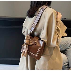 Primer plano del bolso vintage marrón con detalles de perlas y correa tejida de moda