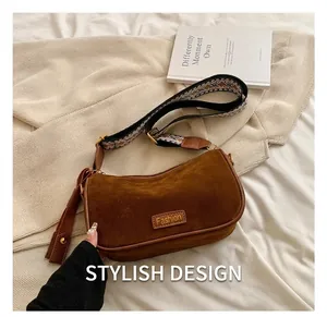 Detail of brown faux suede saddle bag with geometric jacquard strap and fashion tag