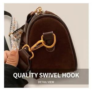 Detail of vintage brown pillow bag showing golden metal hooks and woven shoulder strap