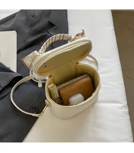 Interior view of small cream cylinder bag showing space for phone and wallet