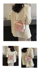 Detail of pink box bag with embossed floral texture and decorative silk scarf handle