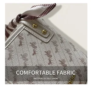 Detail of off-white embossed leather handbag with golden hardware and houndstooth silk scarf
