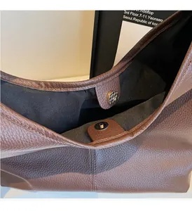 Nahaufnahme der dunkelbraunen Ledertasche mit silbernem Magnetverschluss