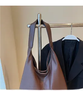Detail der dunkelbraunen Tragetasche aus strukturiertem Leder mit stabilen Griffen