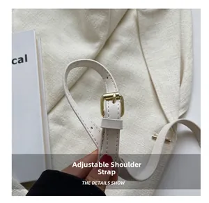 Detail showing the adjustable beige leather strap with high-quality gold metal buckle