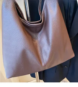 Detail aus weichem braunem Leder mit Lychee-Maserung einer Hobo-Tasche mit sichtbaren Nähten