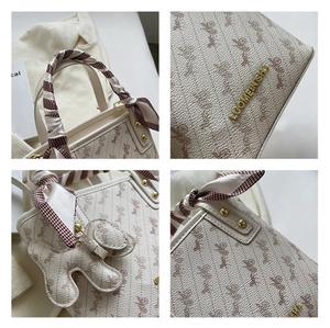 Detail shot of cream textured leather handbag with horse carriage pattern and silk scarf handle