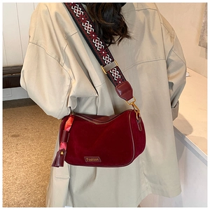 Detail of burgundy velvet crossbody bag with ethnic woven strap and Fashion logo