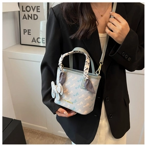 Detail of light blue bucket bag with horse carriage print and silk scarf handle