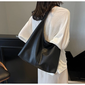 Nahaufnahme einer schwarzen Hobo-Tasche aus strukturiertem Leder am Model getragen