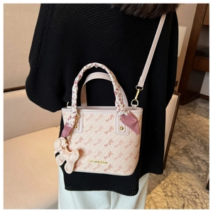 Detailed view of pink handbag with horse carriage pattern and silk scarf handle detail
