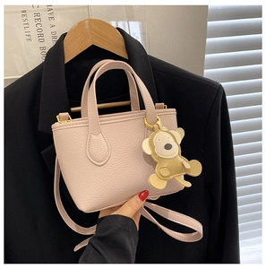 Pink lychee texture bucket bag with a cute monkey charm and matching leather shoulder strap