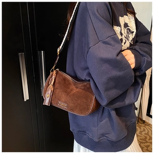 Brown suede pillow bag with fashion nameplate and black-white geometric strap detail