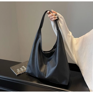 Detail der schwarzen Hobo-Tasche aus Narbenleder mit weicher Textur und Schultergurt