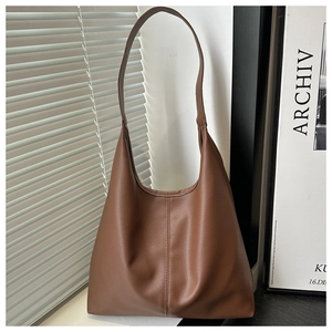 Detailed view of brown lychee leather hobo tote with vertical seam and single shoulder strap