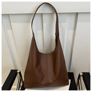 Detail of dark brown hobo shoulder bag with litchi grain texture and vertical stitching