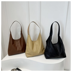 Three minimalist large hobo bags in brown, cream, and black showing pebbled leather texture