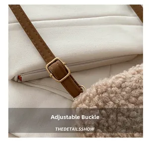 Detail view of the adjustable brown leather strap with a gold metal buckle on a fuzzy bag