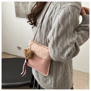 Detailansicht der rosa Pelz-Eimertasche mit süßem Plüschbär-Anhänger an der Seite