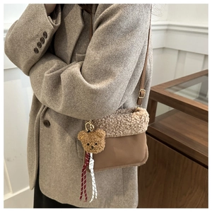 Detail der braunen Teddy-Fleece Beuteltasche mit Bärenanhänger und Seildekoration