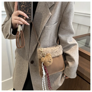 Detail der braunen Winter-Beuteltasche mit beigem Plüsch und süßem Bärenanhänger