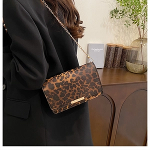 Detail of leopard print flap bag featuring a gold chain strap and sleek metal lock