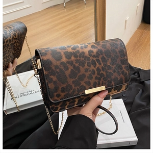 Detailed view of leopard print texture and gold metal chain strap on crossbody bag