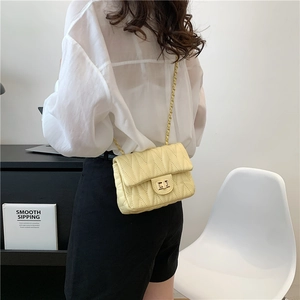 Pale yellow quilted crossbody bag with golden twist lock and metal chain strap for women