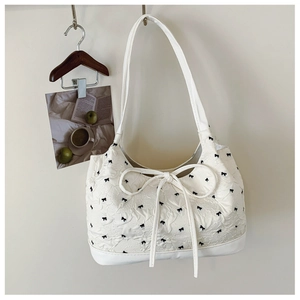 Chic beige shoulder bag with bubble texture and black bow embroidery detailing