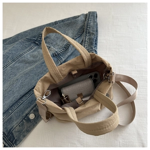 Interior view of khaki nylon tote bag showing storage space for phone and wallet