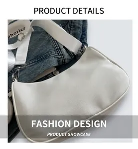 Close-up of white crescent shoulder bag with wide logo strap and silver metal zipper