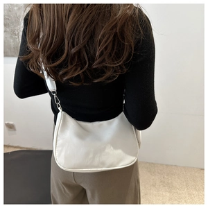 Vue arrière du mannequin portant un sac à bandoulière blanc minimaliste en demi-lune