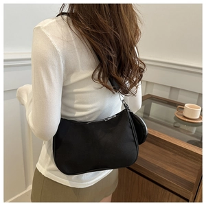 Black nylon crescent shoulder bag with detachable coin purse shown on model back