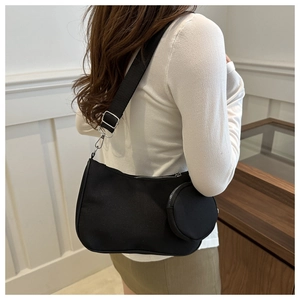 Detail of black crescent shoulder bag with detachable mini coin purse and wide strap