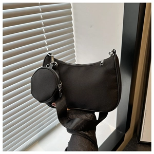 Détail du sac hobo en nylon noir avec large bandoulière et mini pochette amovible