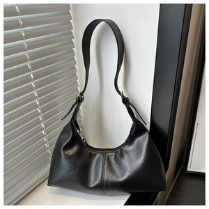 Detail of black suede hobo bag with adjustable strap and artistic shutter light shadows