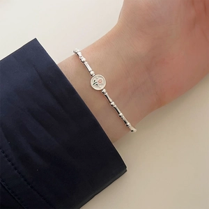 Detail of S925 silver bamboo link bracelet featuring a pink tulip flower disc charm