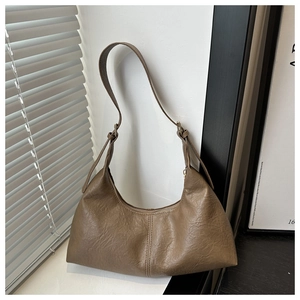 Detail of coffee brown faux suede bag showing smooth zipper and adjustable strap buckle