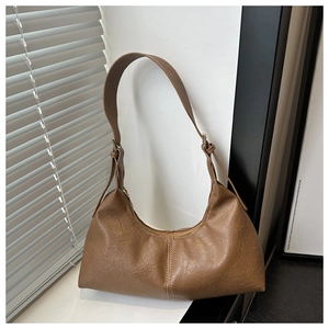 Close-up of vintage brown suede hobo bag with adjustable strap and contrast stitching