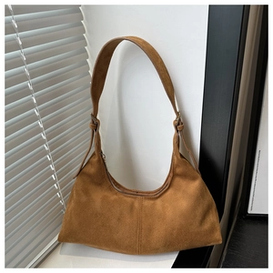 Detail of a brown faux suede tote bag with zipper closure and adjustable metal buckle