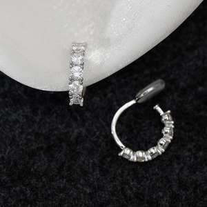 Detail of silver C-shaped clip-on earrings with pavé set cubic zirconia and silicone pads