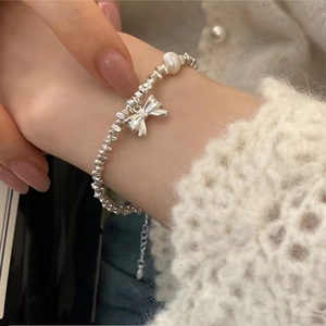 Elegant S925 silver beaded bracelet with bow pendant and pearl on female wrist