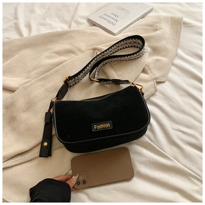 Detail of black matte pillow bag with colorful woven strap compared to a phone size