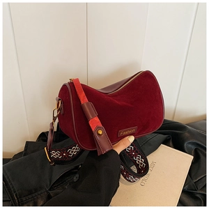 Detail of burgundy suede moon bag with wide embroidered ethnic shoulder strap