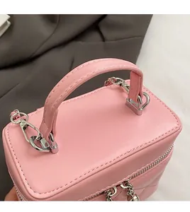 Dettaglio della borsa a secchiello rosa con manico imbottito e dettagli in argento