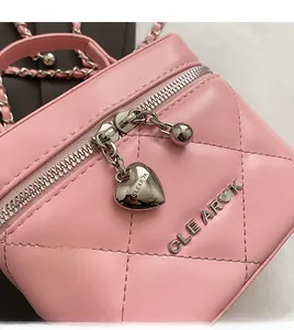 Macro della borsa in pelle rosa trapuntata con cerniere argentate e ciondoli a cuore