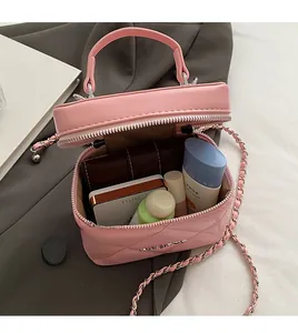 Dettaglio della borsa a secchiello rosa trapuntata che mostra lo spazio per i cosmetici