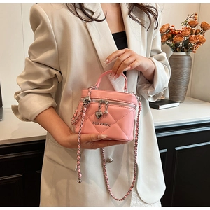Vista dettagliata della borsa a secchiello rosa trapuntata con catena argento