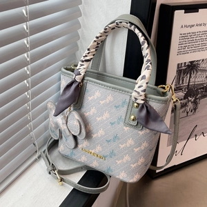 Chic grey-blue crossbody bucket bag with leopard scarf and elephant charm on window sill