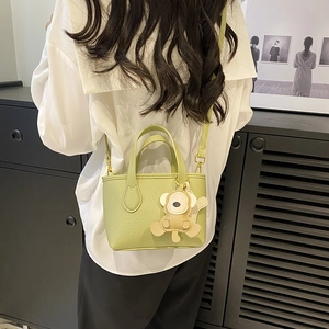 Light green lychee grain bucket bag with cute monkey charm and crossbody strap